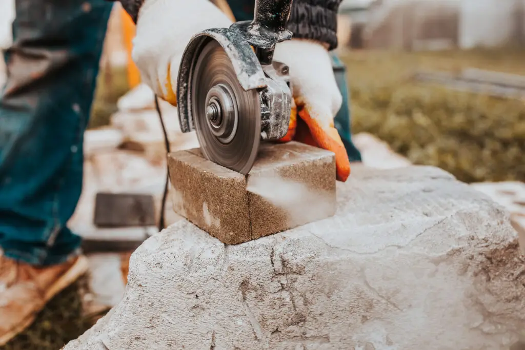 The diamond blade of the grinder quickly and accurately cuts the concrete block